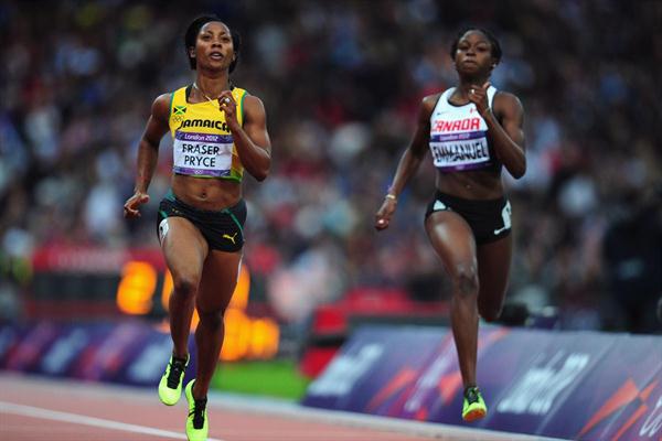 Shelly-Ann Fraser-Pryce of Jamaica runs alongside Crystal Emmanuel of Canada in the Women's 200m heat on Day 10 of the London 2012 Olympic Games on 6 August 2012 (Getty Images)